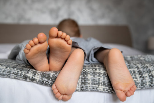 children's legs on a double bed