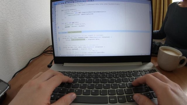 Working From Home on Laptop Coding in Javascript With Cappuccino to Drink While Working