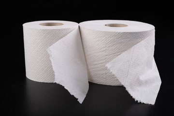 White toilet paper on a dark table. Articles for daily hygiene.