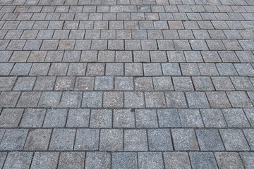 abstract background of the pavement lined with granite tiles close up