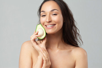 Young beautiful woman holding avocado