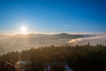 Fototapeta na wymiar Sunrise in the mountains in spring with a roller with fog in the valley, morning in Czech Beskydy
