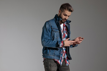 casual guy standing and rubbing hands while looking down dramatic