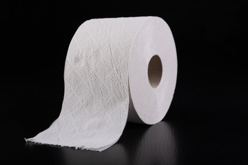 White toilet paper on a dark table. Articles for daily hygiene.