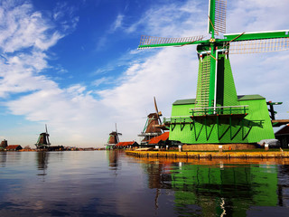 windmill in rotterdam on the calm lake where it reflects the clear sky and the structure of the building