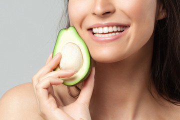 Young beautiful woman holding avocado