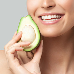 Young beautiful woman holding avocado