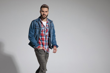 casual man walking with hand in pocket looking at camera