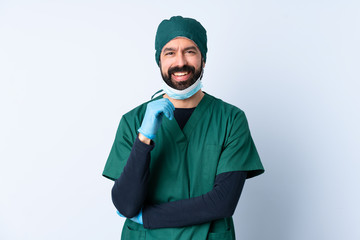 Surgeon man in green uniform over isolated background laughing