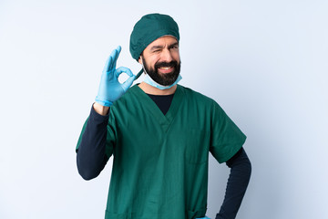 Surgeon man in green uniform over isolated background showing ok sign with fingers