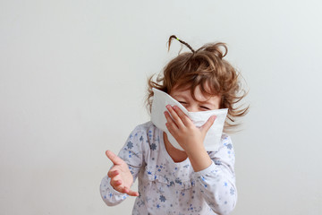 Young girl coughing into a paper handkerchief trying to say something in front of a white background