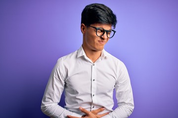 Young handsome business man wearing shirt and glasses over isolated purple background with hand on stomach because indigestion, painful illness feeling unwell. Ache concept.