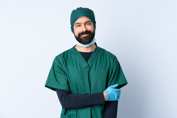 Surgeon man in green uniform over isolated background laughing