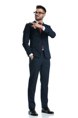businessman standing one way while looking and pointing the other