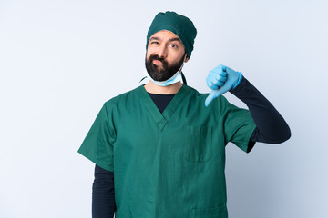 Surgeon man in green uniform over isolated background showing thumb down with negative expression