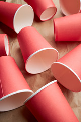 pile of disposable red paper cups on paper background. eco friendly concept. look from above. background backdrop