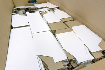 A lot of cardboard packaging for mugs. Disassembled condition, not folded. White color outside. Production. Wholesale and retail trade. Side view.