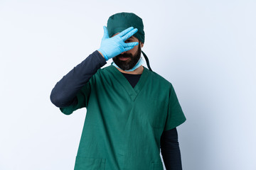 Fototapeta na wymiar Surgeon man in green uniform over isolated background covering eyes by hands and smiling