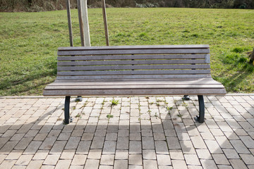 lonely empty park bench on cobblestones
