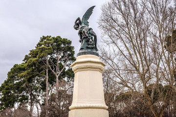 Fototapeta na wymiar Famous Fallen Angel sculpture on a fountain in Retiro Park in Madrid city, Spain