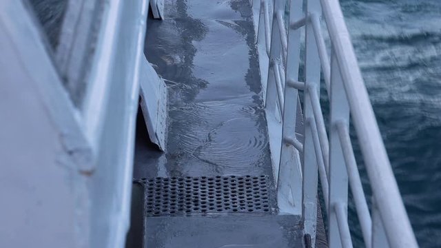 Water wetting the deck of a catamaran and moving chain