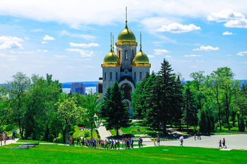  Church with golden domes under the sun on Mamaev Kurgan on the Volga against the blue sky and...