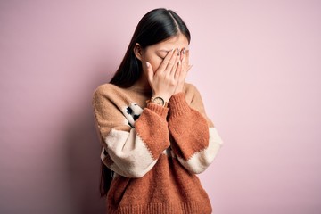 Young beautiful asian woman wearing animal print fashion sweater over pink isolated background with...