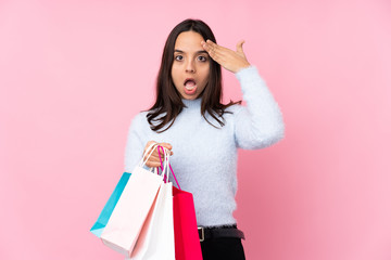 Young woman with shopping bag over isolated pink background has just realized something and has intending the solution