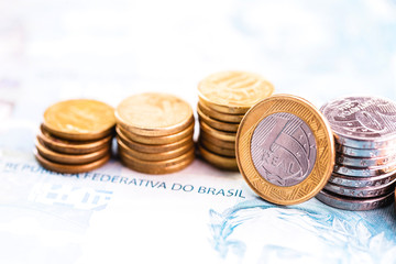 one real coin and gold bars. Concept of appreciation of the Brazilian currency in the stock market.