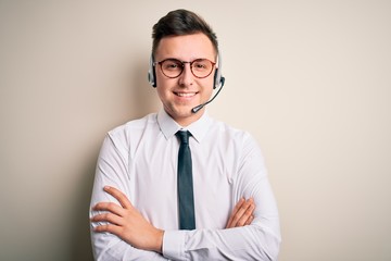 Young handsome caucasian business man wearing call center headset at customer service happy face smiling with crossed arms looking at the camera. Positive person. - Powered by Adobe