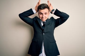 Young handsome business man wearing elegant suit and tie over isolated background Doing bunny ears gesture with hands palms looking cynical and skeptical. Easter rabbit concept.