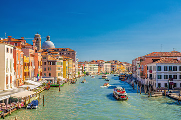 Venice cityscape with Grand Canal waterway. View from Scalzi bridge. Gondolas, boats, yachts, vaporettos docked and sailing Canal Grande. Venetian architecture buildings. Veneto Region, Italy.