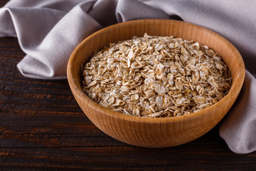 raw oatmeal on a wooden rustic background