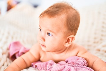 Adorable baby lying down over blanket on the sofa at home. Newborn relaxing and resting comfortable