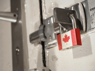 A bolted door secured by a padlock with the national flag of Canada on it.(series)