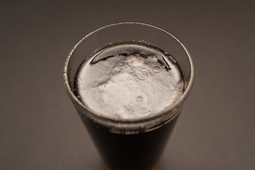 glass with carbonated drink on black background