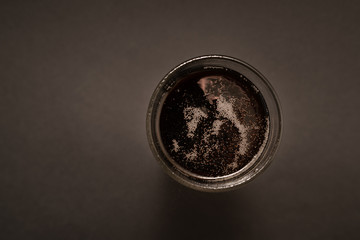 glass with carbonated drink on black background