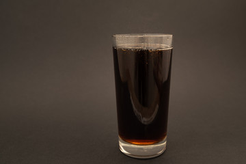 glass with carbonated drink on black background