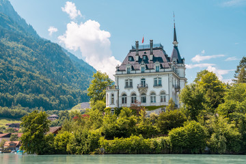 Schloss Seeburg. Seeburg castle was built on peninsula surrounded by the teal coloredwaters of lake Brienz. Iseltwald, Switzerland.