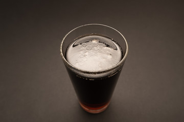 glass with carbonated drink on black background