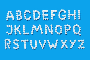 inscription from pills on a blue background. letters of medicine, alphabet