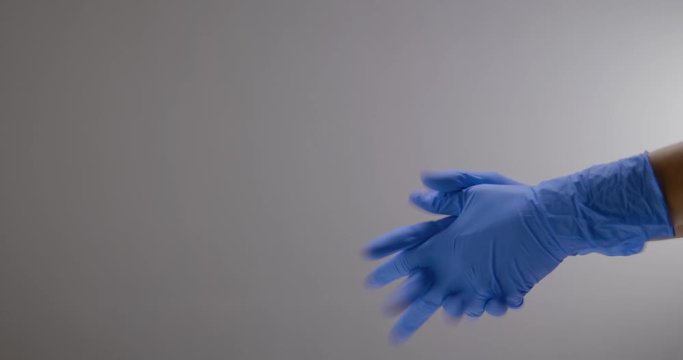 Hands slipping on gloves to not get infected