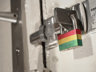 A bolted door secured by a padlock with the national flag of Bolivia on it.(series)
