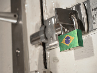 A bolted door secured by a padlock with the national flag of Brazil on it.(series)