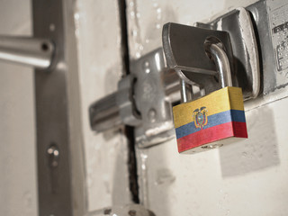 A bolted door secured by a padlock with the national flag of Ecuador on it.(series)