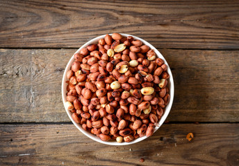 Roasted peanuts, salt, put in a cup. Brown was placed on the wooden floor.