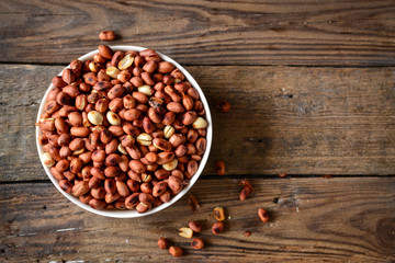 Roasted peanuts, salt, put in a cup. Brown was placed on the wooden floor.