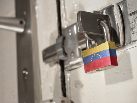 A bolted door secured by a padlock with the national flag of Venezuela on it.(series)