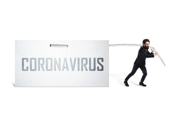 Fototapeta premium Caucasian businessman pulling inscription coronavirus on a white sheet, global virus crisis concept