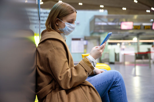 Woman upset over flight cancellation, writes message to family, sitting in almost empty airport terminal due to coronavirus pandemic/Covid-19 outbreak travel restrictions. Quarantine measure